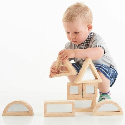 Menino a brincar com blocos de construção de madeira de formas geométricas