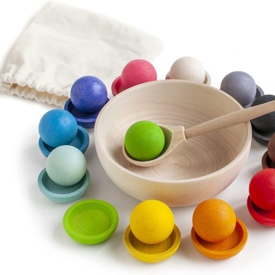 Conjunto de bolas, pratos e tigela de madeira colorida com colher e saco de pano branco