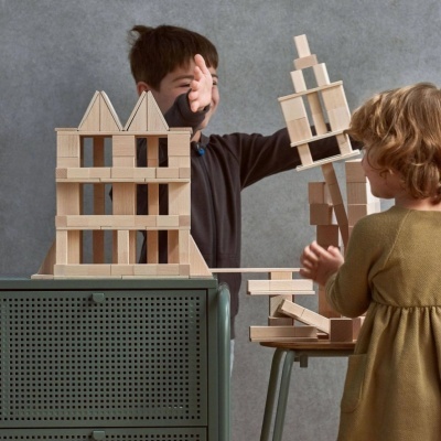 Crianças a brincar com blocos de madeira empilhados em estruturas