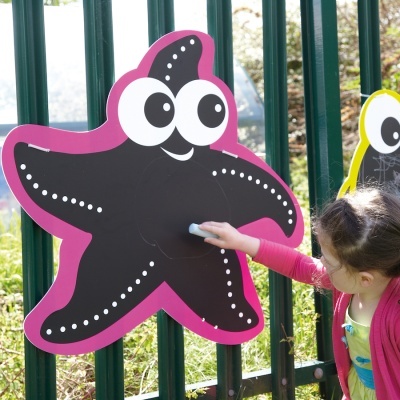 Estrela-do-mar decorativa preta com contorno rosa no portão verde