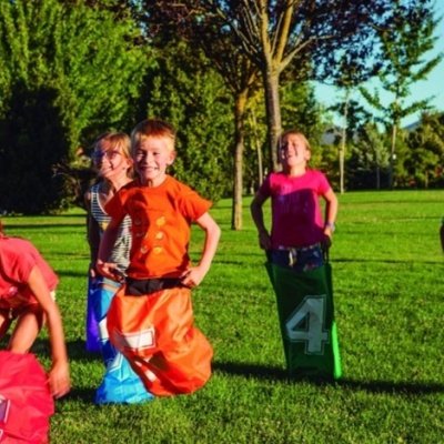 Crianças a jogar corrida em sacos coloridos num parque