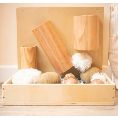 Acessórios decorativos de madeira e têxteis em caixa de madeira clara