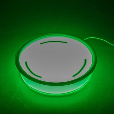 Base redonda branca iluminada em verde com cabo conectado