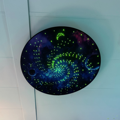 Plafon redondo esverdeado no teto com padrão de estrelas e galáxias.