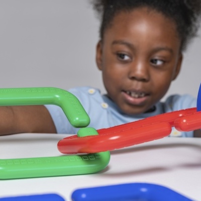 Criança a brincar com brinquedos de encaixe coloridos