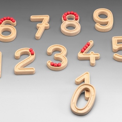 Números de madeira com contas vermelhas para aprendizagem sobre fundo cinzento.