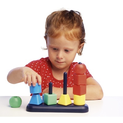 Menina a brincar com brinquedo educativo de blocos de madeira coloridos