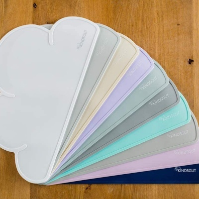 Amostras de cores em formato arredondado em tons pastel sobre madeira