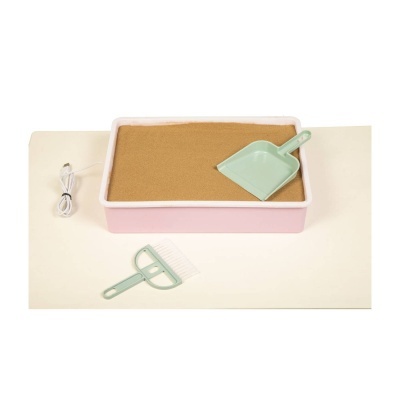 Caixa rosa com areia e pá verde claro junto a pente e cabo USB