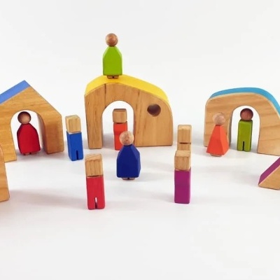 Brinquedos em madeira coloridos com figuras humanas e casas