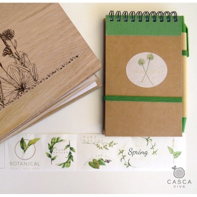 Dois cadernos com temática botânica, etiquetas com texto e superfície clara.