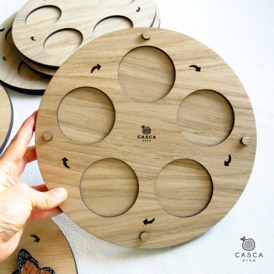 Prato redondo de madeira com cinco recortes circulares e logótipo CASCA VIVA