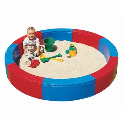 Caixa de areia circular vermelha e azul com bebé e brinquedos de areia