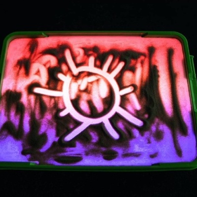 Recipiente com tampa verde decorada com padrão de areia colorida e figura de sol