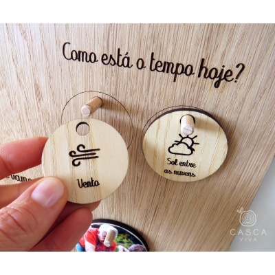 Painel de madeira clara com texto recortado e discos redondos de madeira com ícones do tempo
