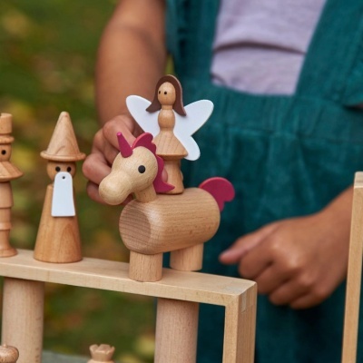 Brinquedo de madeira com cavalo e figura de anjo em fundo desfocado