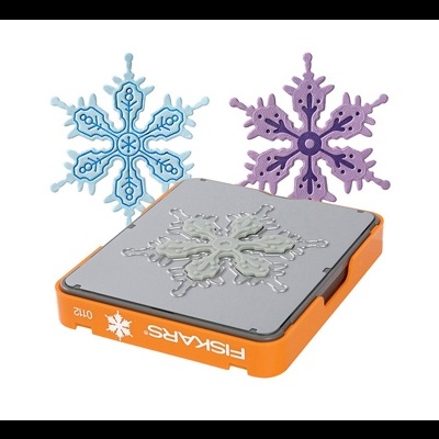 Molde laranja FISKARS para recorte em forma de floco de neve com dois flocos recortados azuis e roxos