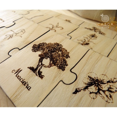 Peças de puzzle de madeira com gravuras a laser de árvores e flores e a palavra Madeira