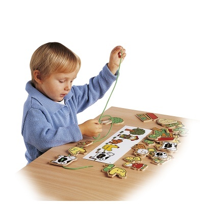 Criança a brincar com brinquedos de madeira para enfiar fios em formas de animais