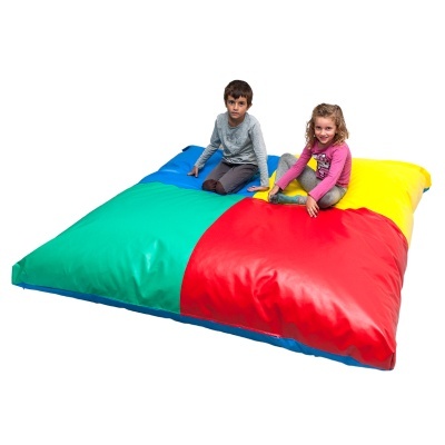 Almofada gigante colorida com duas crianças sentadas, azul, verde, vermelho e amarelo.
