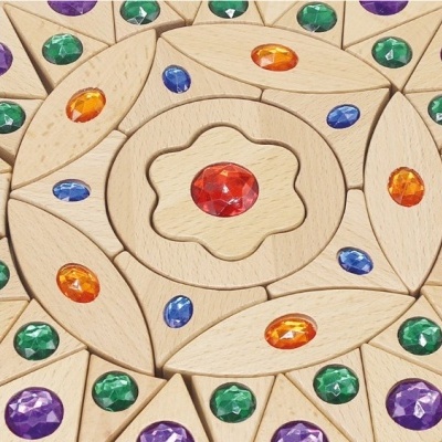 Peças de madeira com pedras coloridas embutidas formando padrão circular.