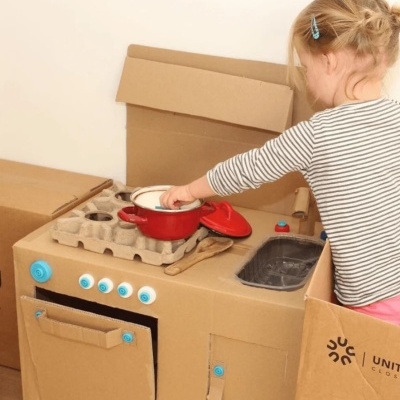 Cozinha de brincar em cartão com forno, lava-louça, fogão e panela vermelha com tampa
