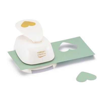 Furador de papel branco da marca Vaessen Creative com formato de coração a perfurar papel verde.