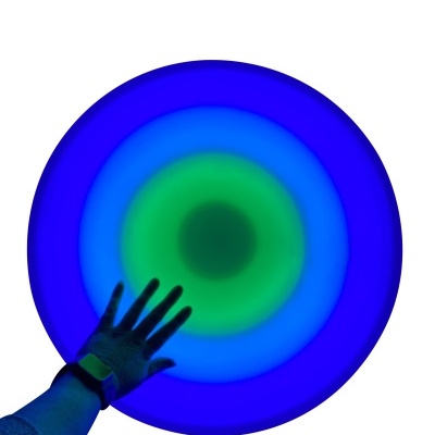 Prato circular luminoso com anéis coloridos e mão a tocar na superfície