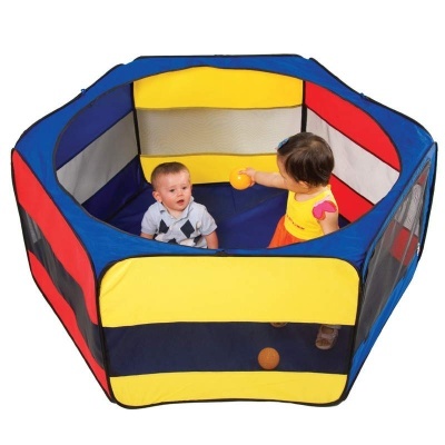 Parque infantil hexagonal colorido com dois bebés e bolas laranja dentro