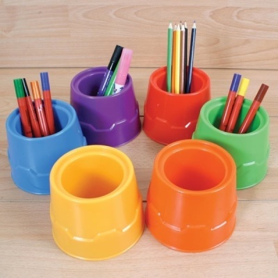 Conjunto de potes coloridos para material de escrita sobre mesa de madeira