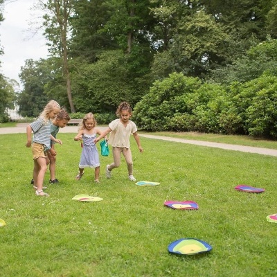 Crianças a jogar num parque com almofadas coloridas no chão
