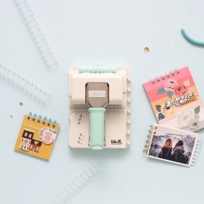 máquina de encadernação We R The Cinch com cadernos coloridos e decoração