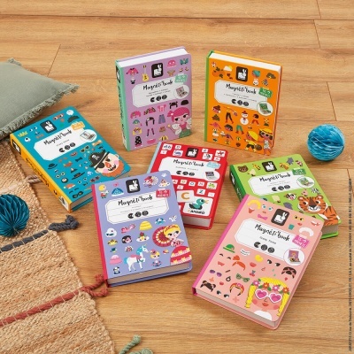 Livros magnéticos infantis coloridos com ilustrações variadas colocados sobre chão de madeira