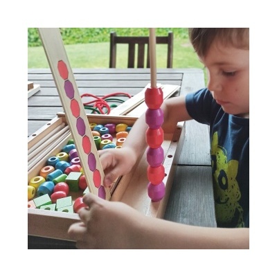 Brinquedo educativo em madeira com contas coloridas e painel de padrões para correspondência