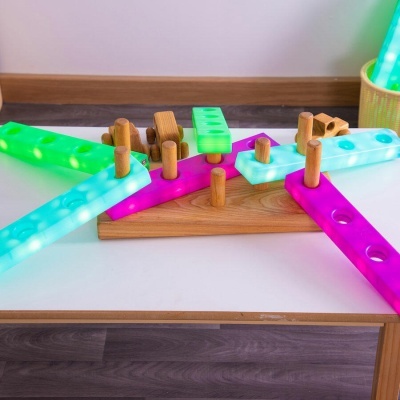 Brinquedo educativo de montagem em madeira e plástico colorido sobre mesa branca