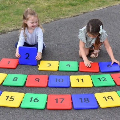Tapetes de jogo numerados coloridos usados por crianças ao ar livre