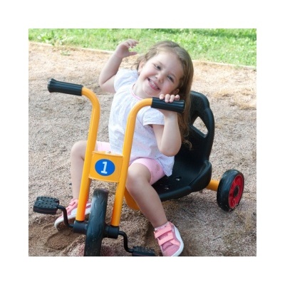 Criança num triciclo amarelo e preto ao ar livre