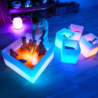 Caixas translúcidas iluminadas com criança a brincar