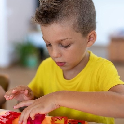 Menino a jogar com peças de brinquedo coloridas