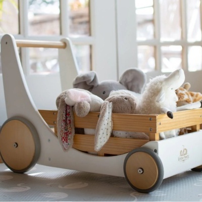 Caminhador de madeira cinza com rodas e peluches dentro em chão cinza