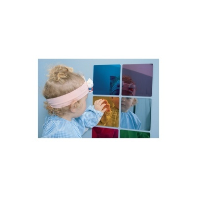 Criança tocando mosaico de painéis coloridos na parede