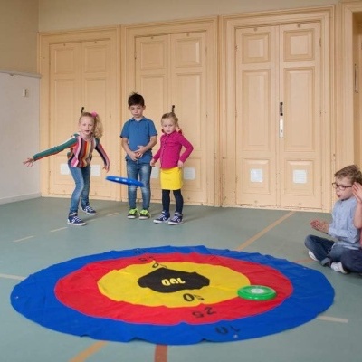 Tapete de jogo colorido redondo no chão com crianças a brincar numa sala