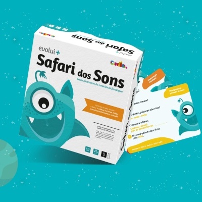 Jogo de cartas Safari dos Sons com caixa e cartas coloridas sobre fundo azul com planetas.