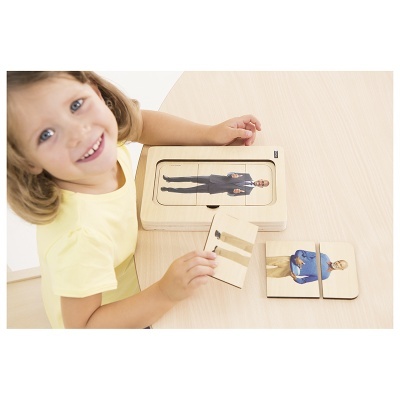 Criança a montar puzzle de madeira com figuras humanas sobre mesa clara