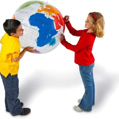 Crianças a segurar um globo terrestre grande e colorido