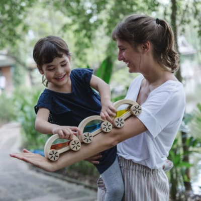Brinquedo de madeira colorido e criança ao ar livre