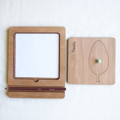 Conjunto de tabuleiros de madeira clara com desenho de folha e canetas vinho