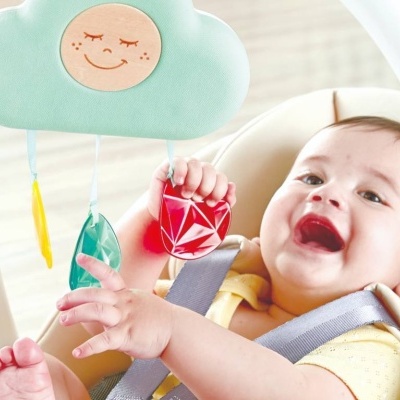 Bebé a brincar com brinquedo pendurado em forma de nuvem azul com pingentes coloridos