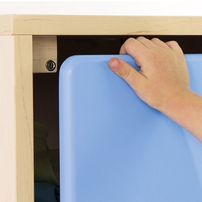 Mão numa cadeira azul junto a estrutura de madeira clara