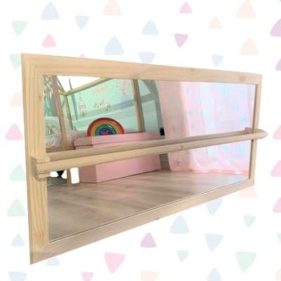 Espelho retangular com suporte de madeira refletindo quarto com arco-íris